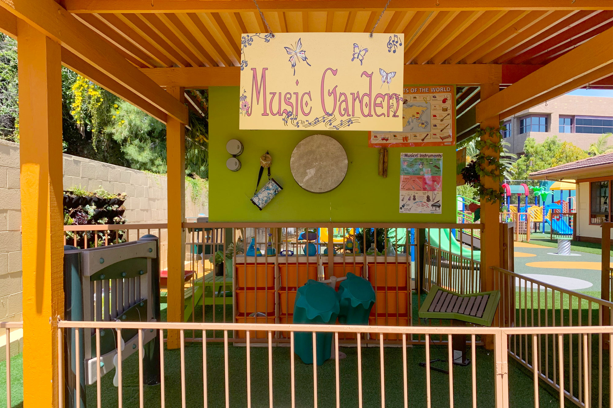 Children learning music with world instruments and dancing in an outdoor music garden setting at Academy on the Hills