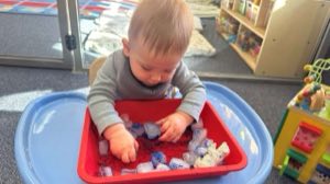Infant exploring a music and movement activity at Academy on the Hills in Aliso Viejo