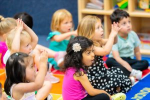 Teacher guiding a young child through a hands-on art and creative expression project in a Montessori-inspired preschool classroom