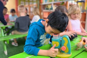 Kindergarten student using a microscope during a science lesson at Academy on the Hills