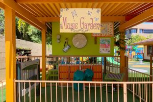 Preschool children playing drums and world instruments in an outdoor music learning environment at Academy on the Hills
