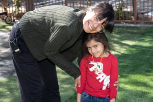 Teachers working closely with young children at Academy on the Hills